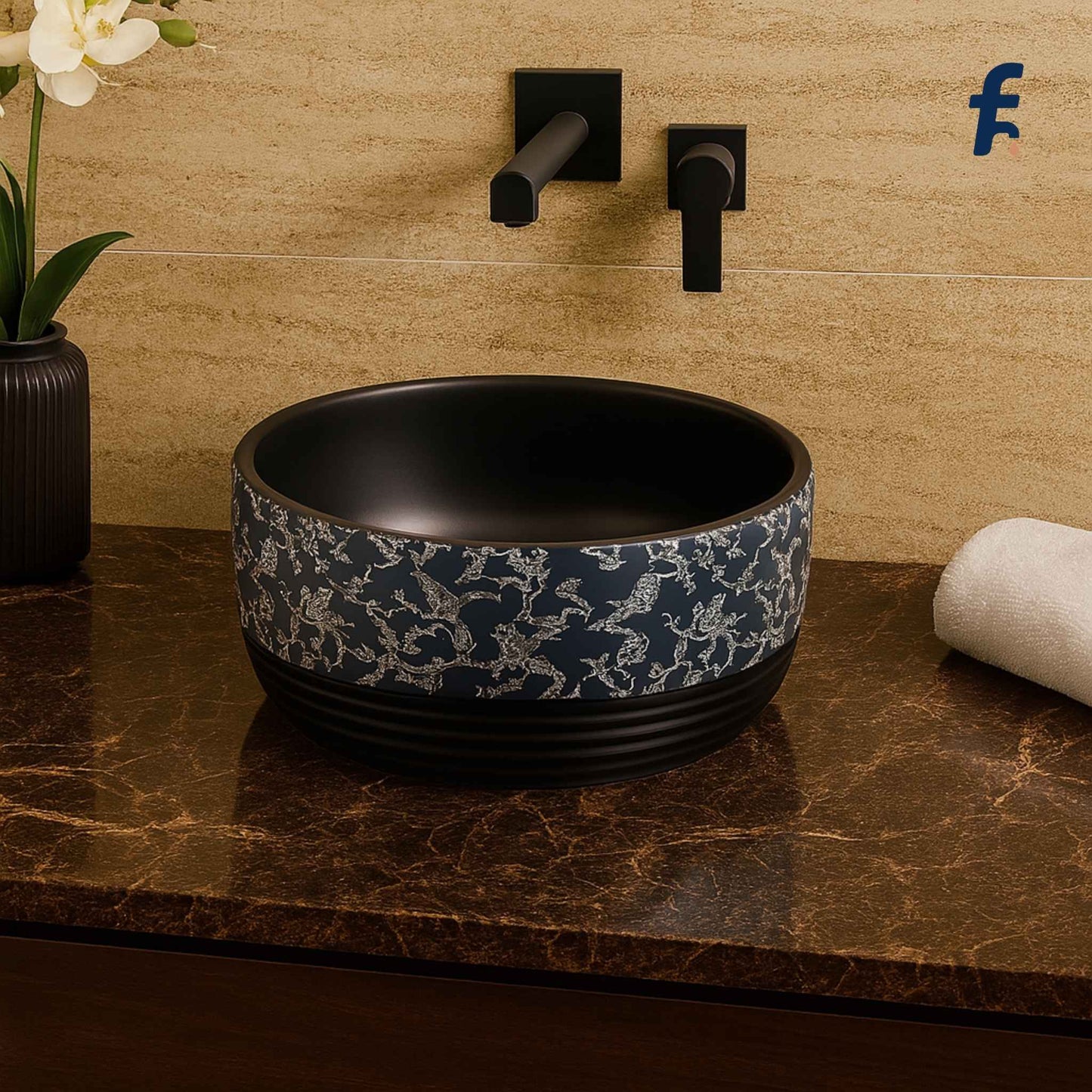 Front view of EQTT-515 glossy black round wash basin with intricate floral design, placed in a luxurious marble bathroom setup with gold wall-mounted faucet.