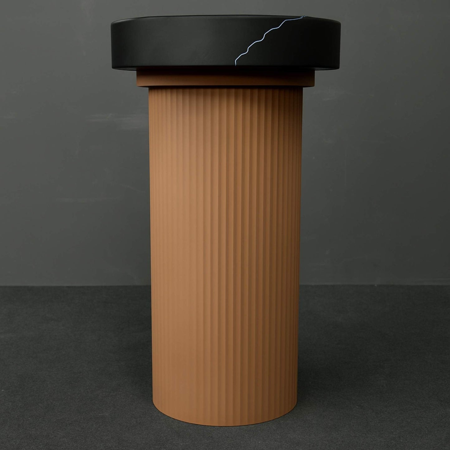 Front view of matte black and desert brown pedestal basin with fluted base