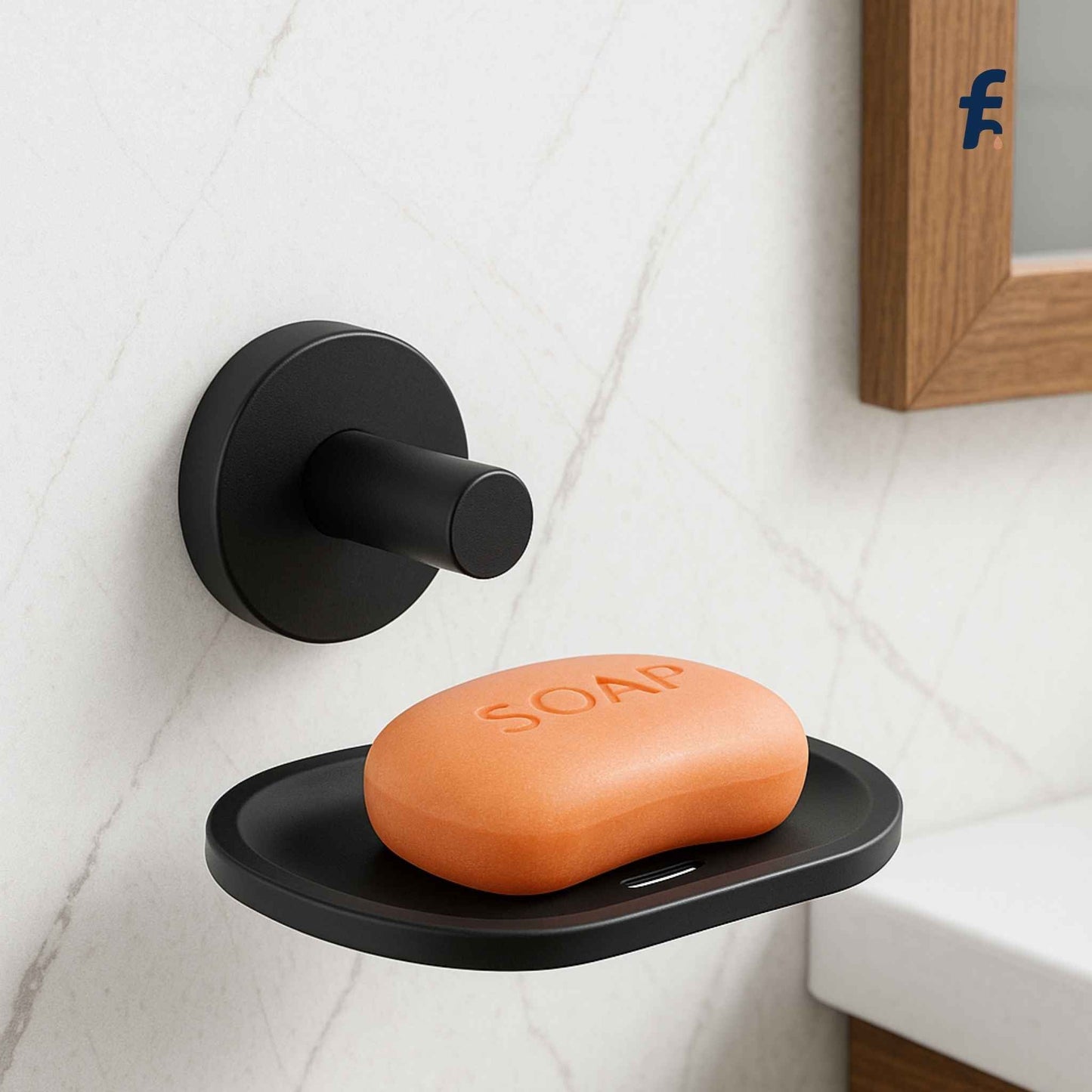 Black soap dish with an orange bar of soap labeled 'SOAP' on a tiled bathroom wall.