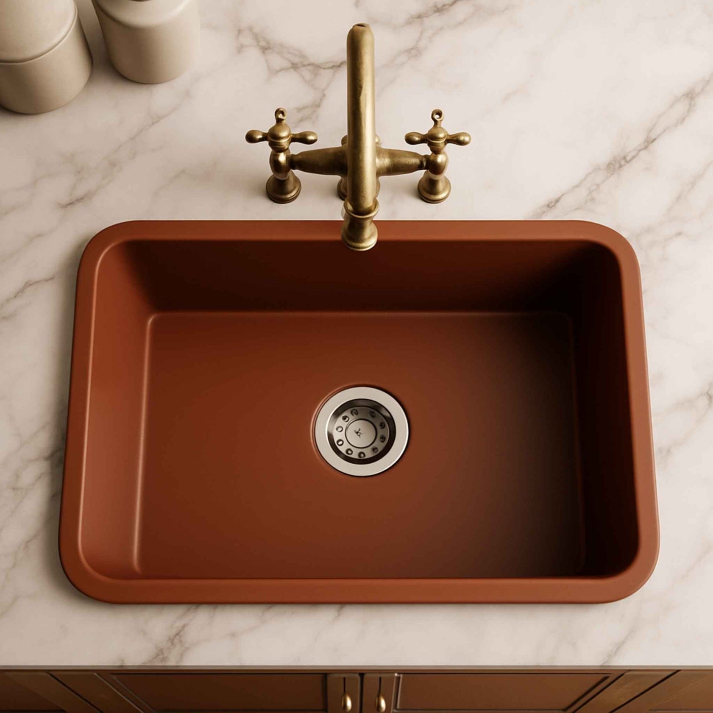 Brown kitchen sink with brass faucet on a marble countertop
