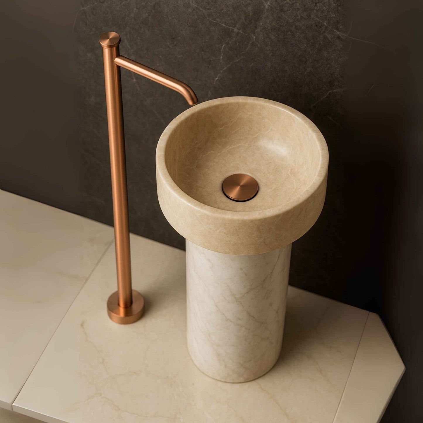 Brushed rose gold floor basin mixer in luxury bathroom with pedestal basin