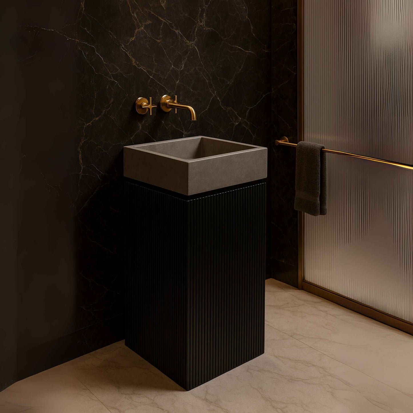 Side view of a modern black pedestal basin with matte grey bowl placed in a luxurious marble bathroom with gold fittings.