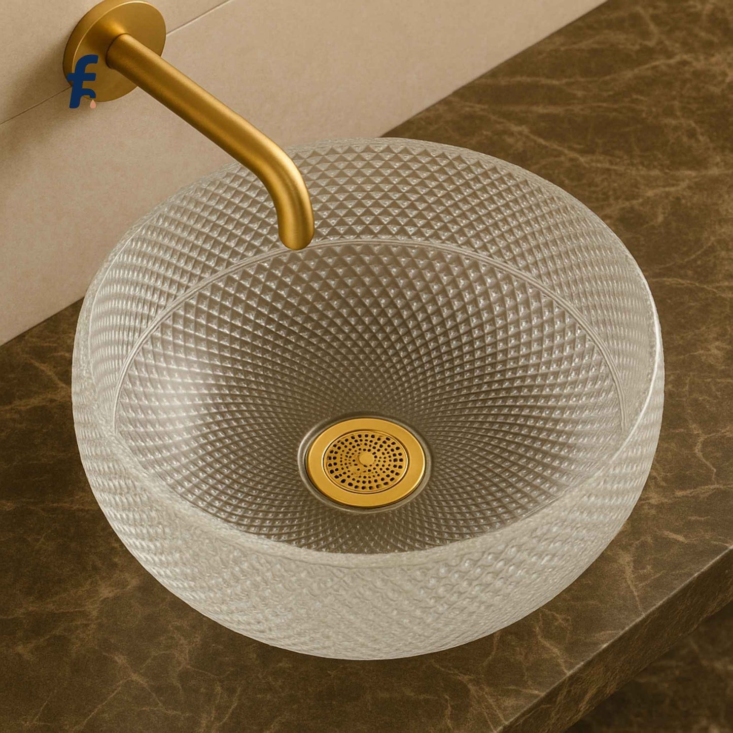 Glass sink with textured design and gold faucet on a marble countertop