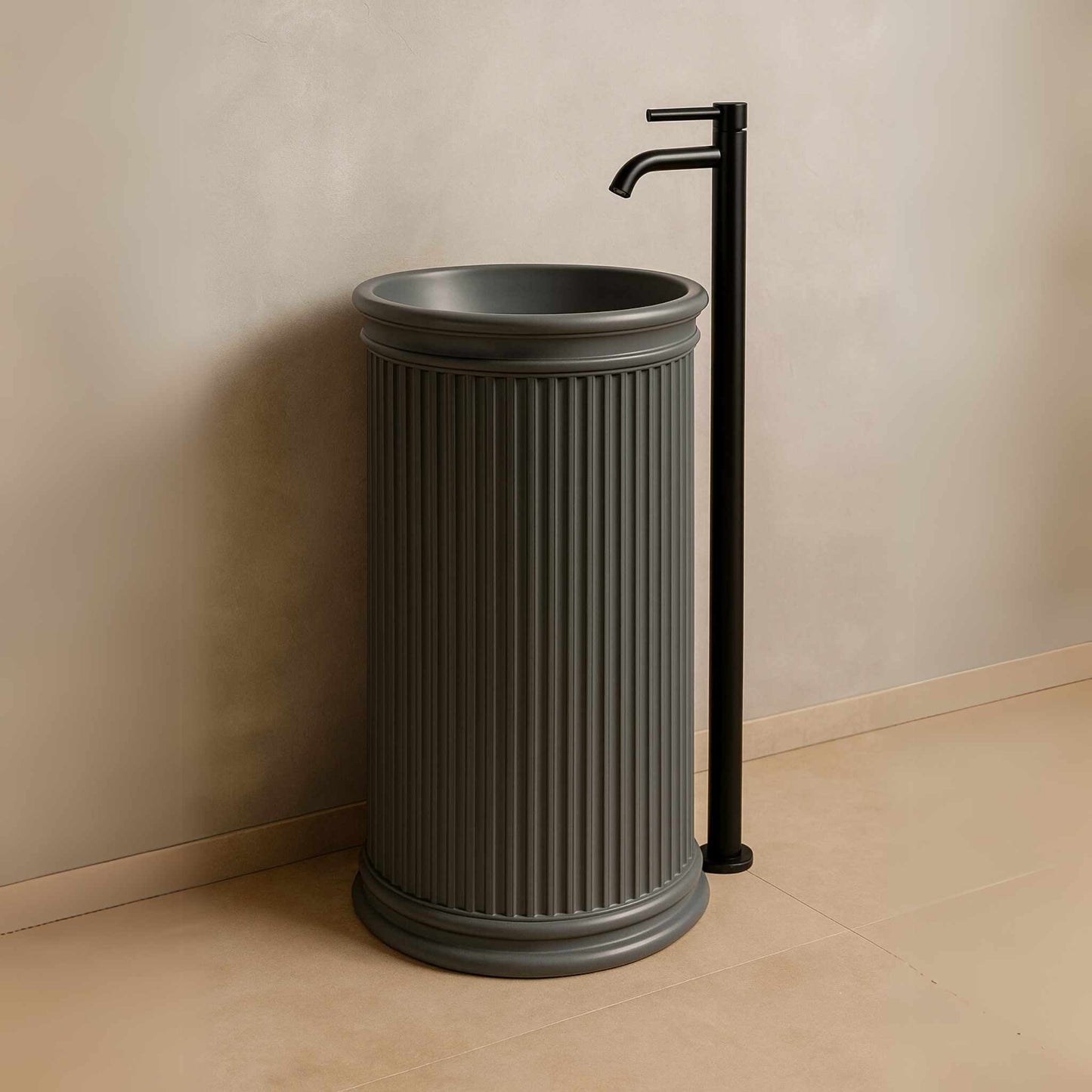 Side angle of matte grey pedestal basin with standing black faucet