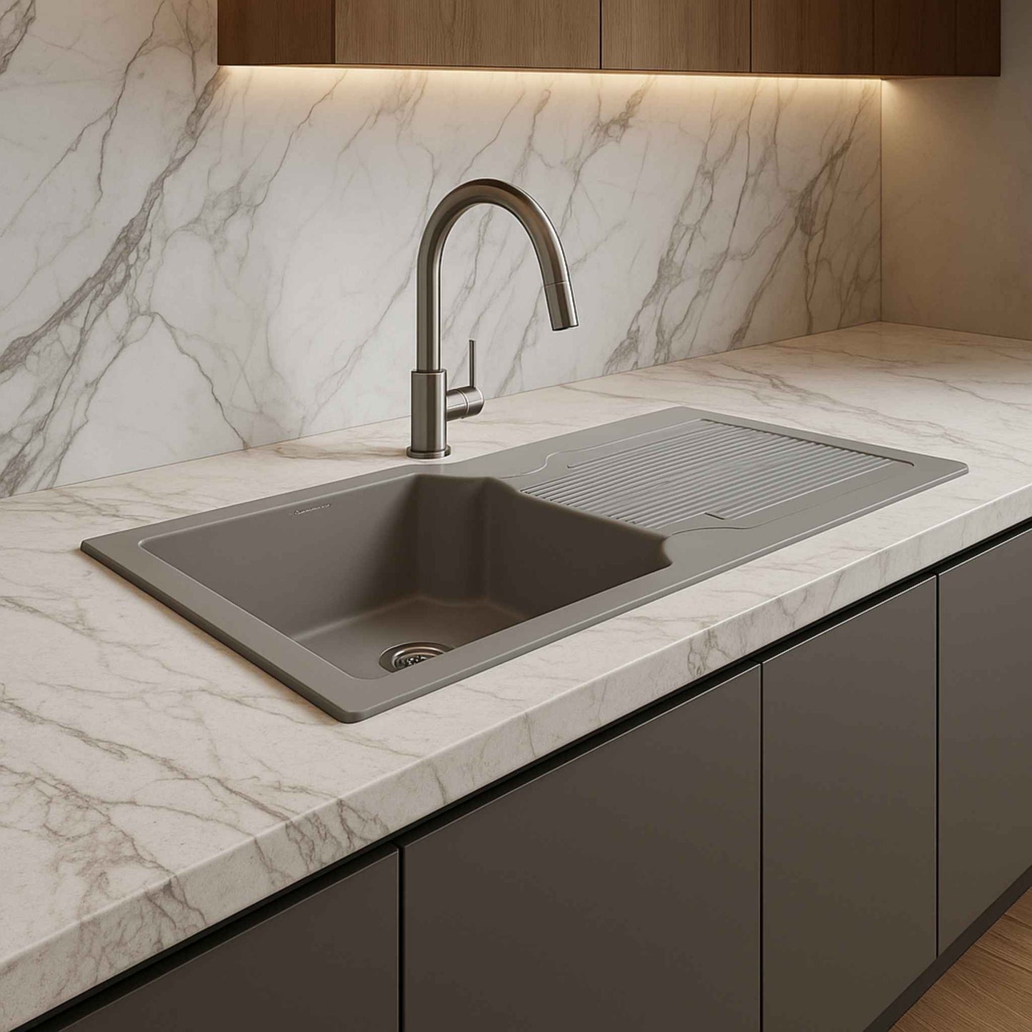 Side angle of grey granite kitchen sink placed on elegant kitchen counter with modern backsplash