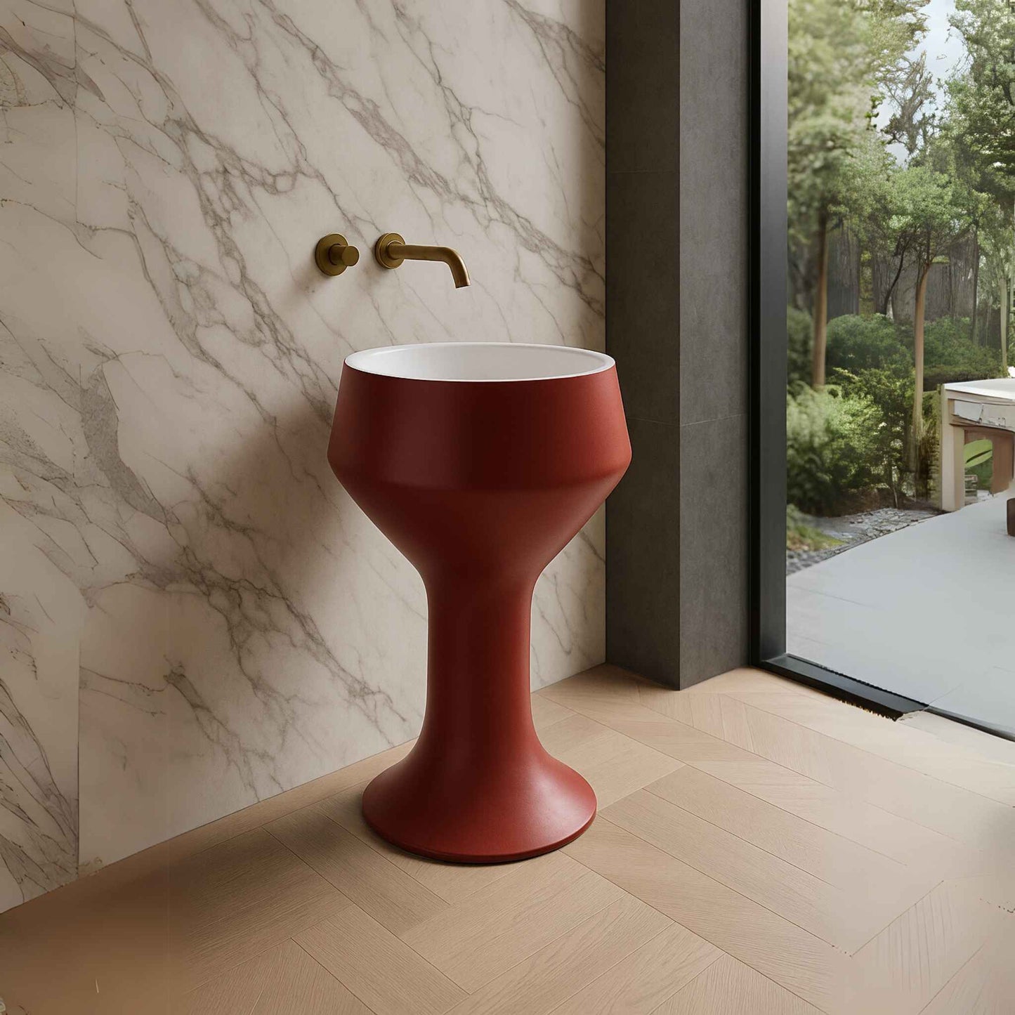 Designer red pedestal basin placed in a spacious marble-clad bathroom