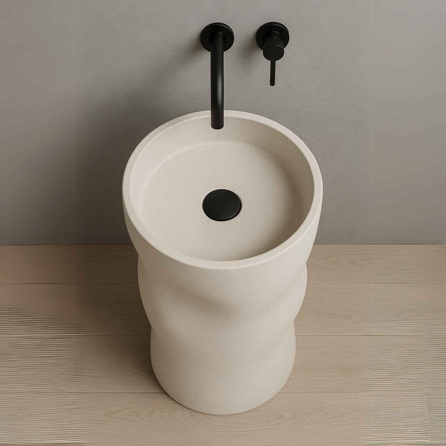Luxury sculpted pedestal washbasin in matte ivory finish with wall-mounted black faucet placed in a high-end bathroom setting top angle