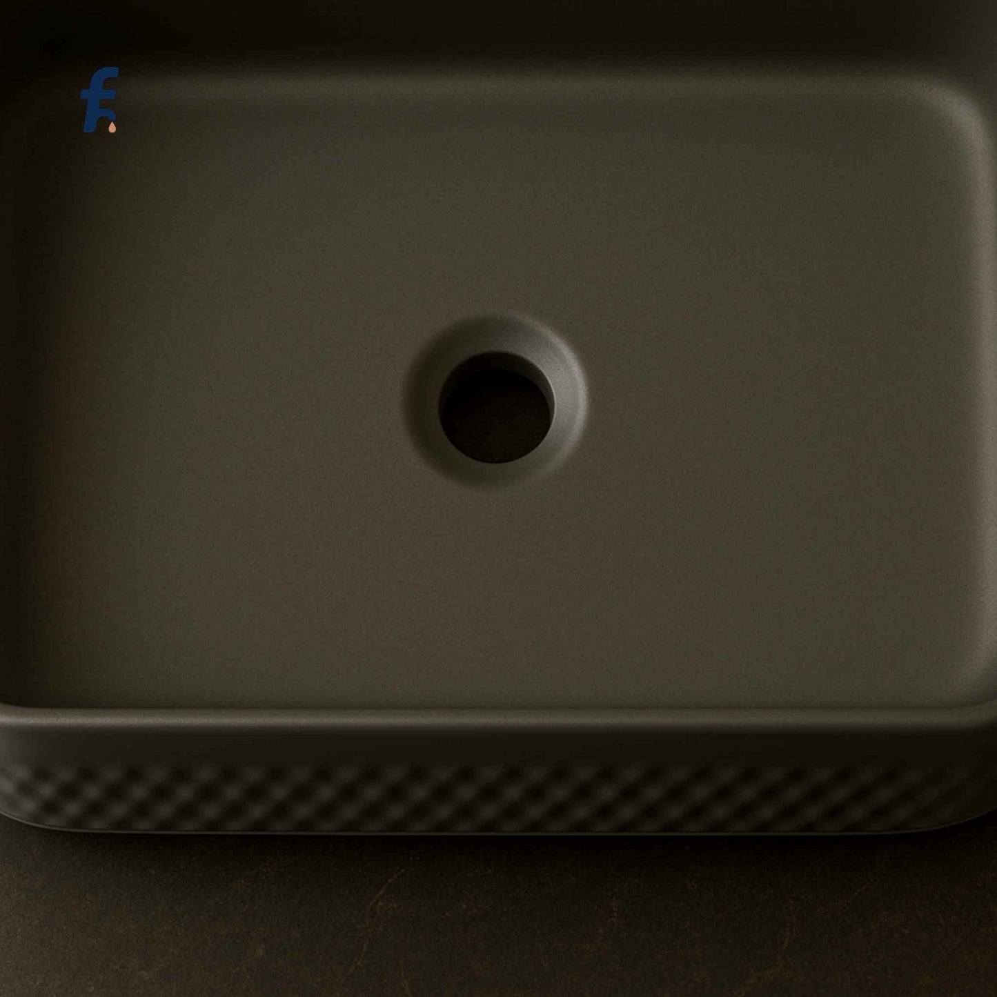 Dark gray rectangular object with a circular hole on a dark background