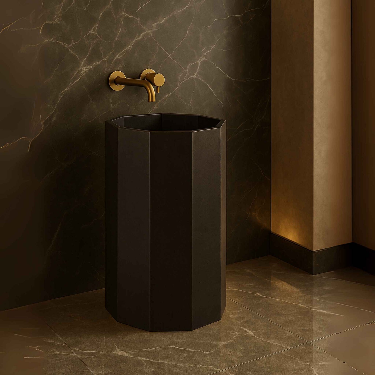 Black freestanding sink with gold faucet against a marble wall.
