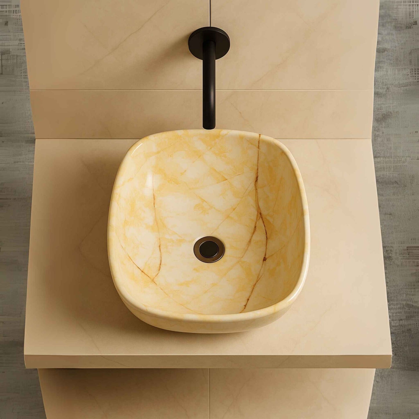 Top angle view of a designer oval marble washbasin with smooth stone texture and polished golden accents.