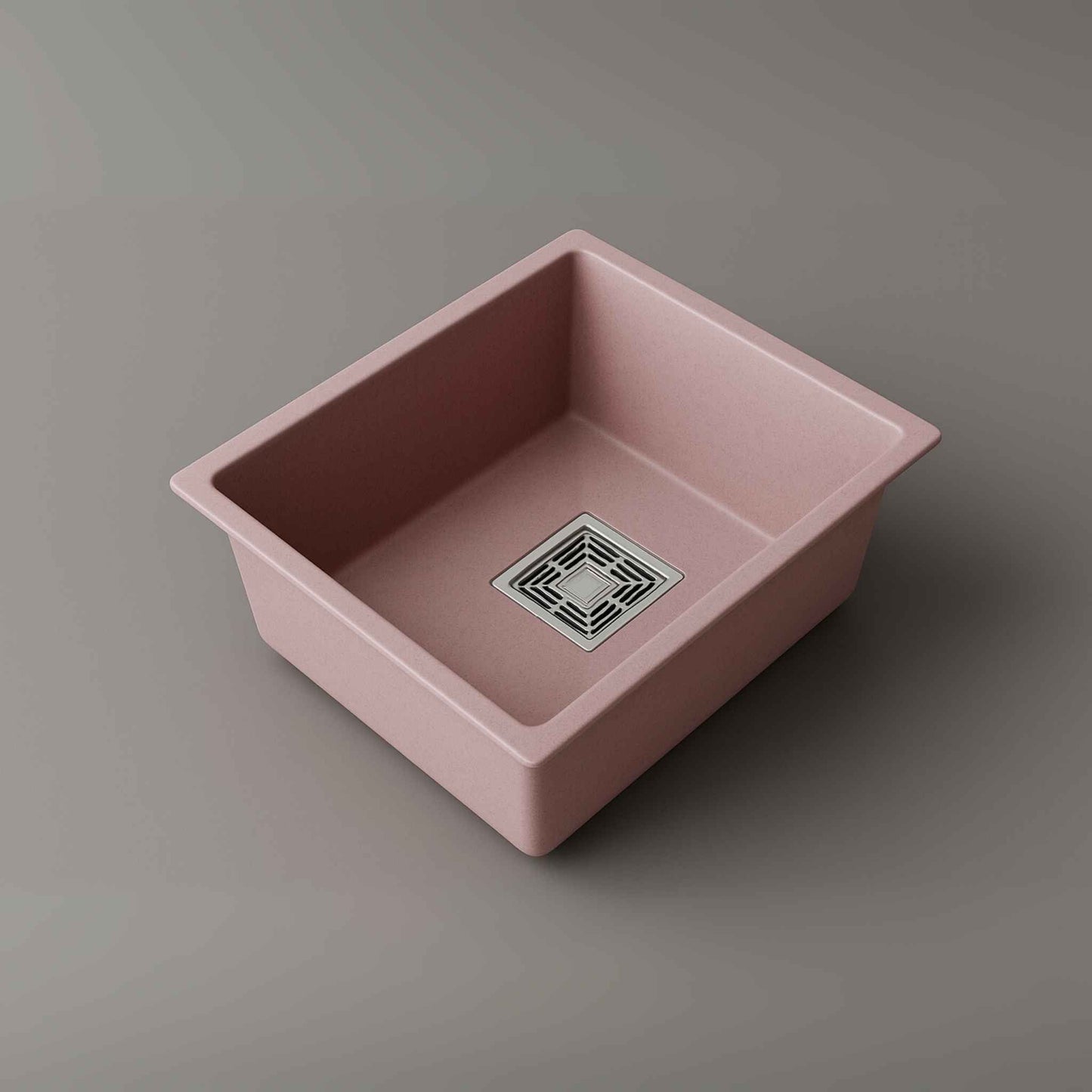 Close-up of stainless steel square waste coupling and drainpipe attached to pink quartz kitchen sink.