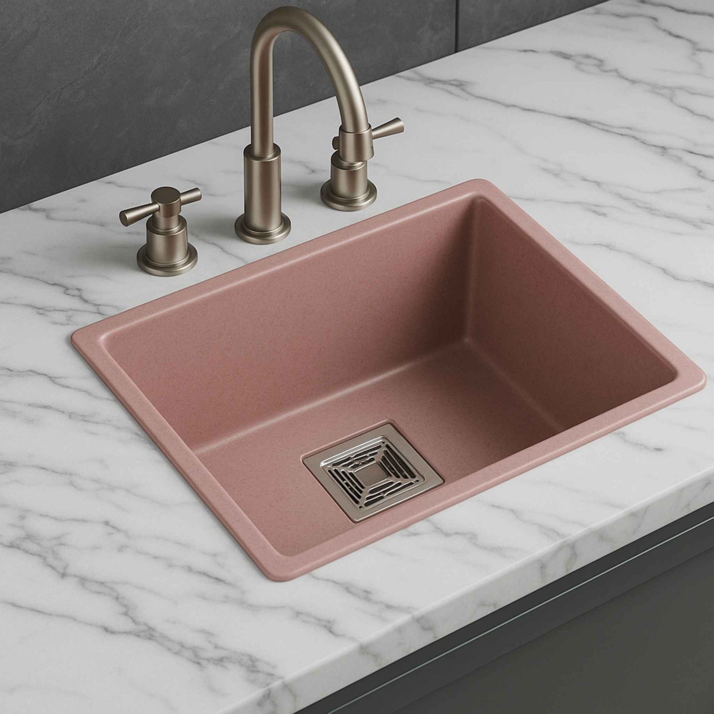 Side angle of modern pink granite kitchen sink with elegant slope and stylish square waste coupling.