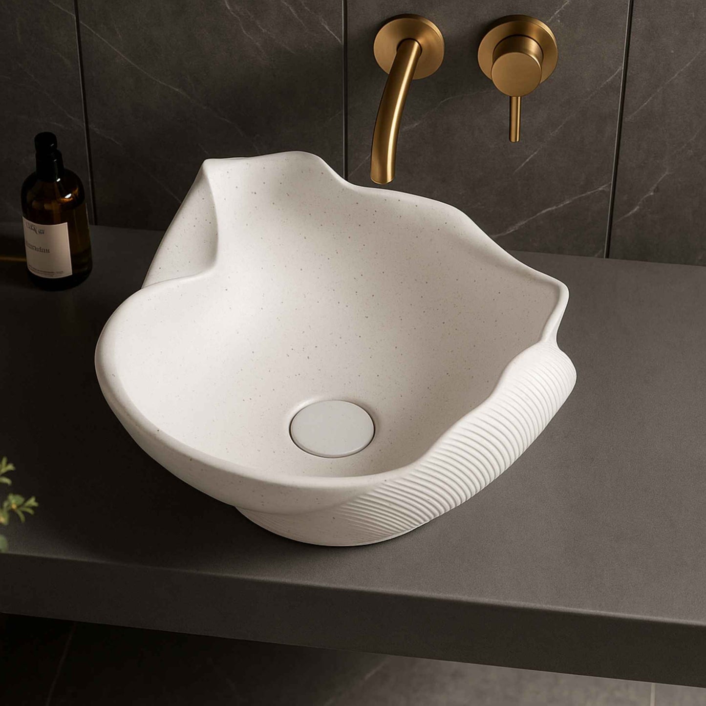 Top angle view of sculptural shell bathroom sink in dark countertop