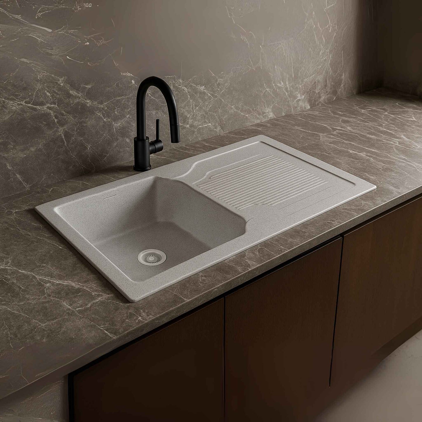 Side close-up view of silver granite kitchen sink with black faucet in modern kitchen setting.