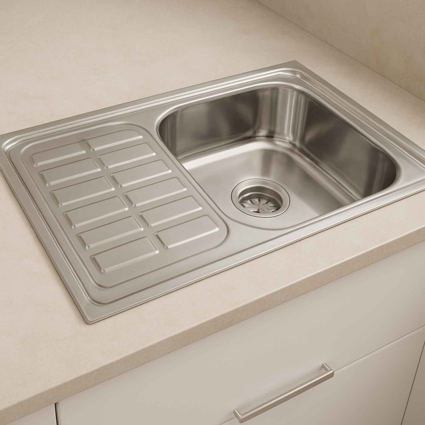 Stainless steel sink with drainboard installed in modern beige kitchen