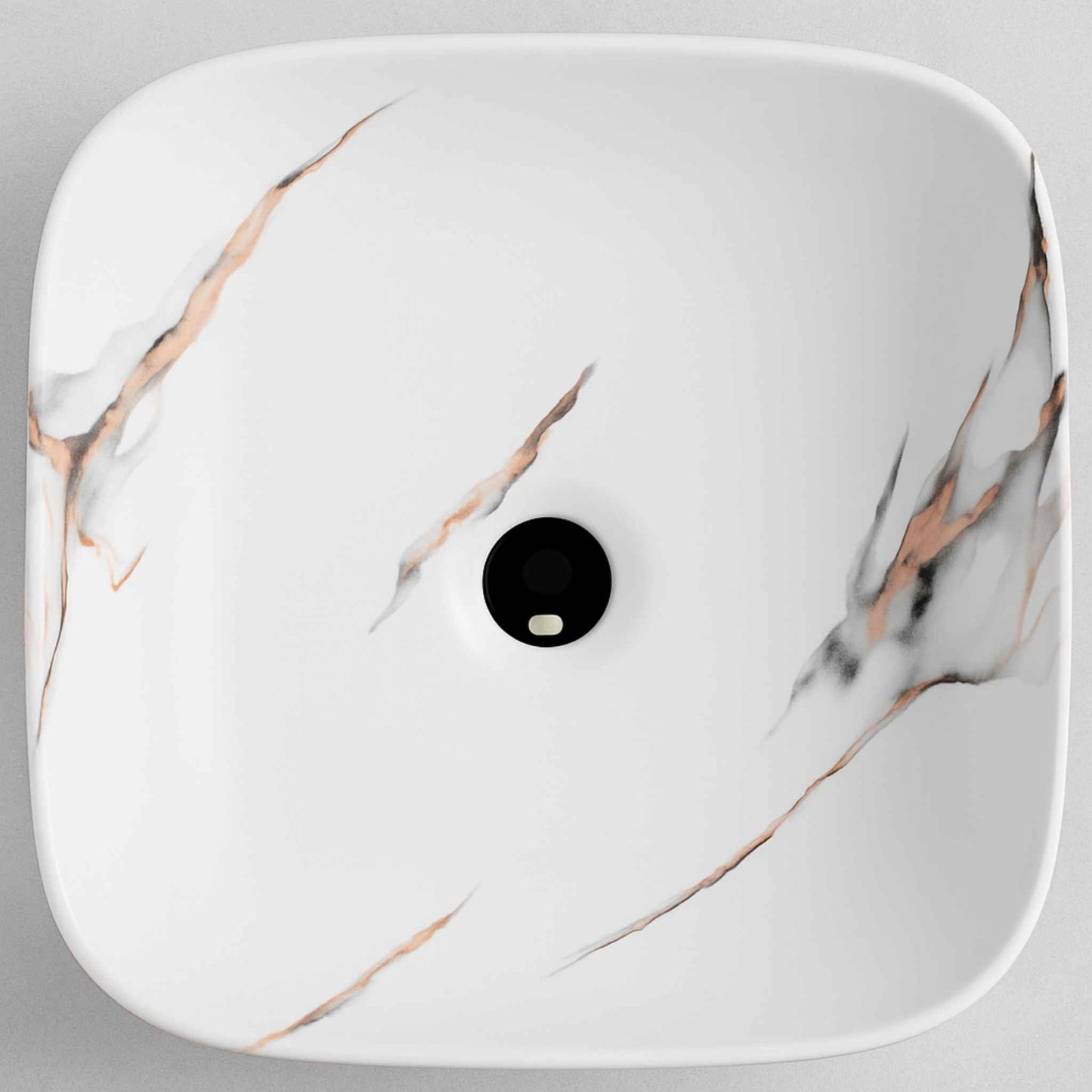 Top angle of white marble countertop basin featuring copper and charcoal vein detailing