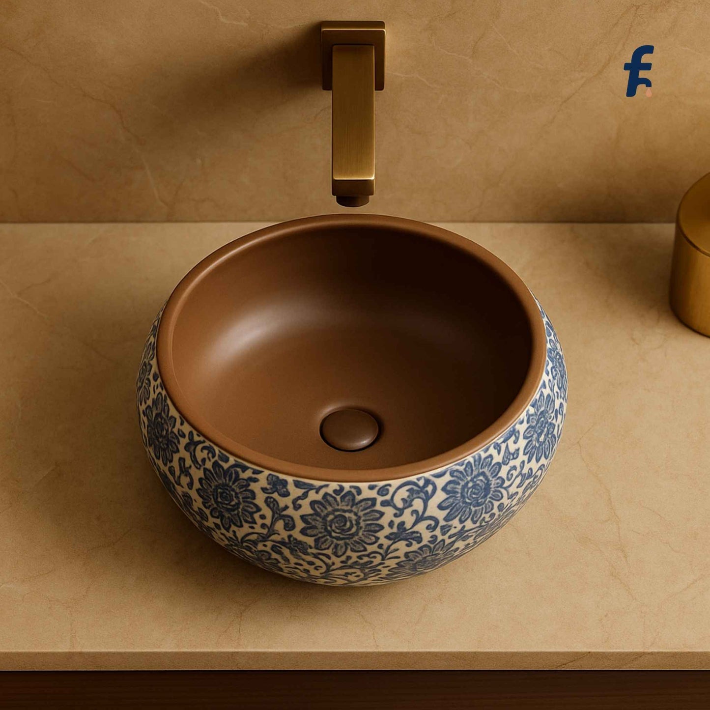 Ceramic sink with blue floral patterns on a beige countertop with a gold faucet.