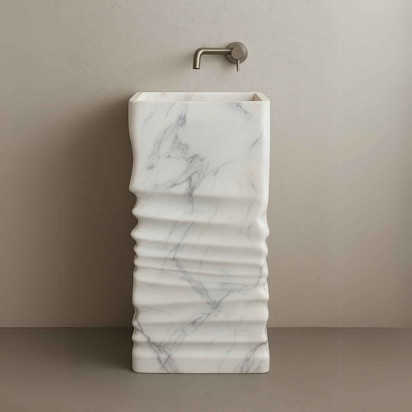 Side angle of sculpted white pedestal basin with wall-mounted faucet in neutral setting