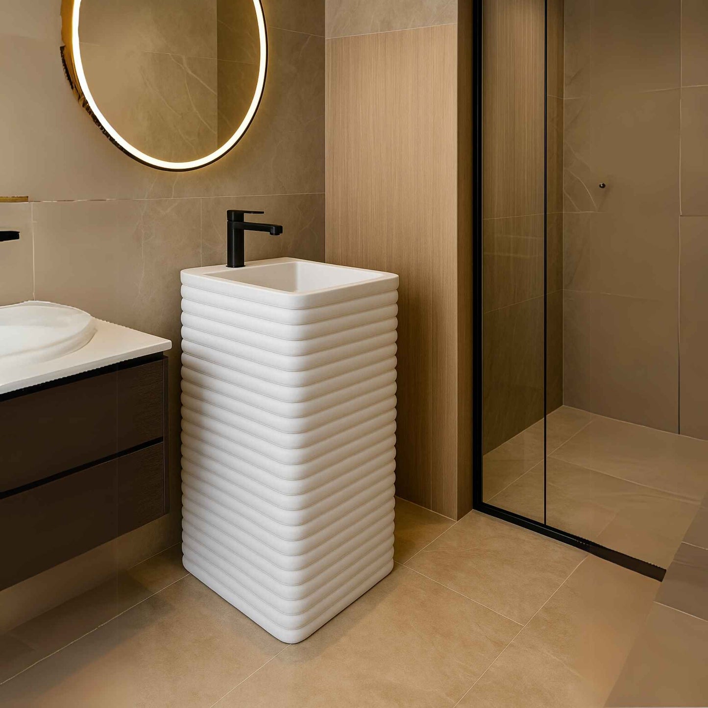 White ribbed pedestal basin in luxurious modern bathroom with LED mirror and shower