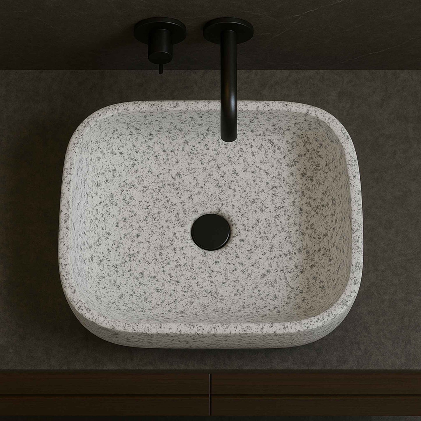 Top angle of rectangular white speckled granite countertop sink with black drain and faucet