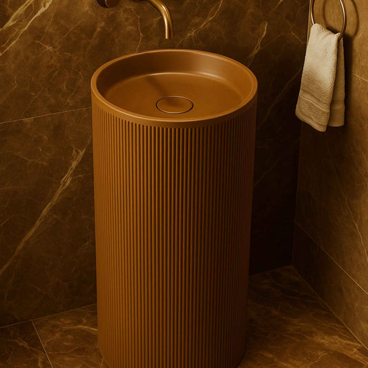Brown freestanding sink in a bathroom with marble walls and a towel.