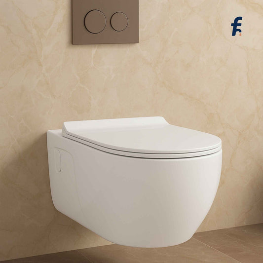 Wall-mounted white toilet against a beige tiled wall with a brand logo in the corner.