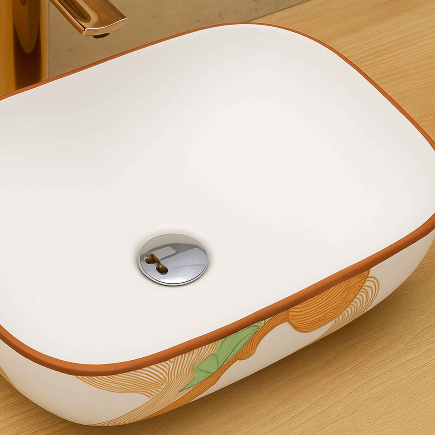 White ceramic sink with decorative brown and green patterns on a wooden surface