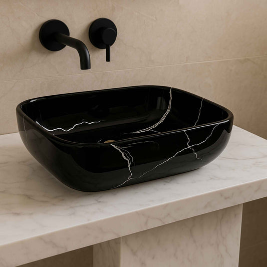 Front view of black marble rectangular wash basin with white veining and matte black faucet