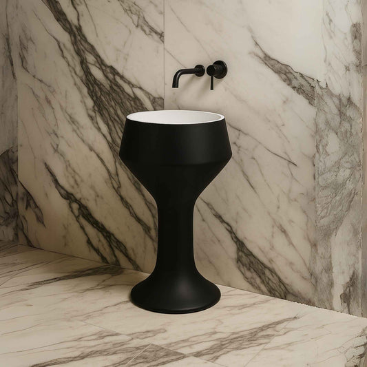 Side view of matte black pedestal sink in luxury marble bathroom with wall faucet