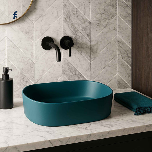Teal sink on a marble countertop with black fixtures and a chevron-patterned wall.