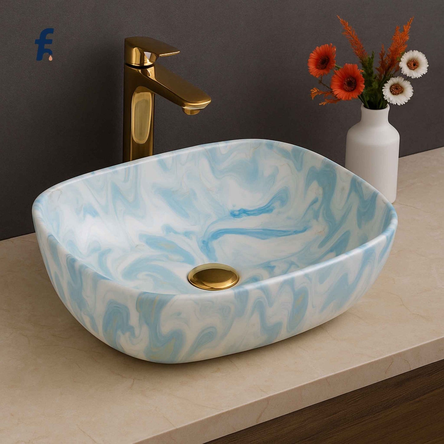 Marble-patterned sink with gold faucet and vase of flowers on a countertop,