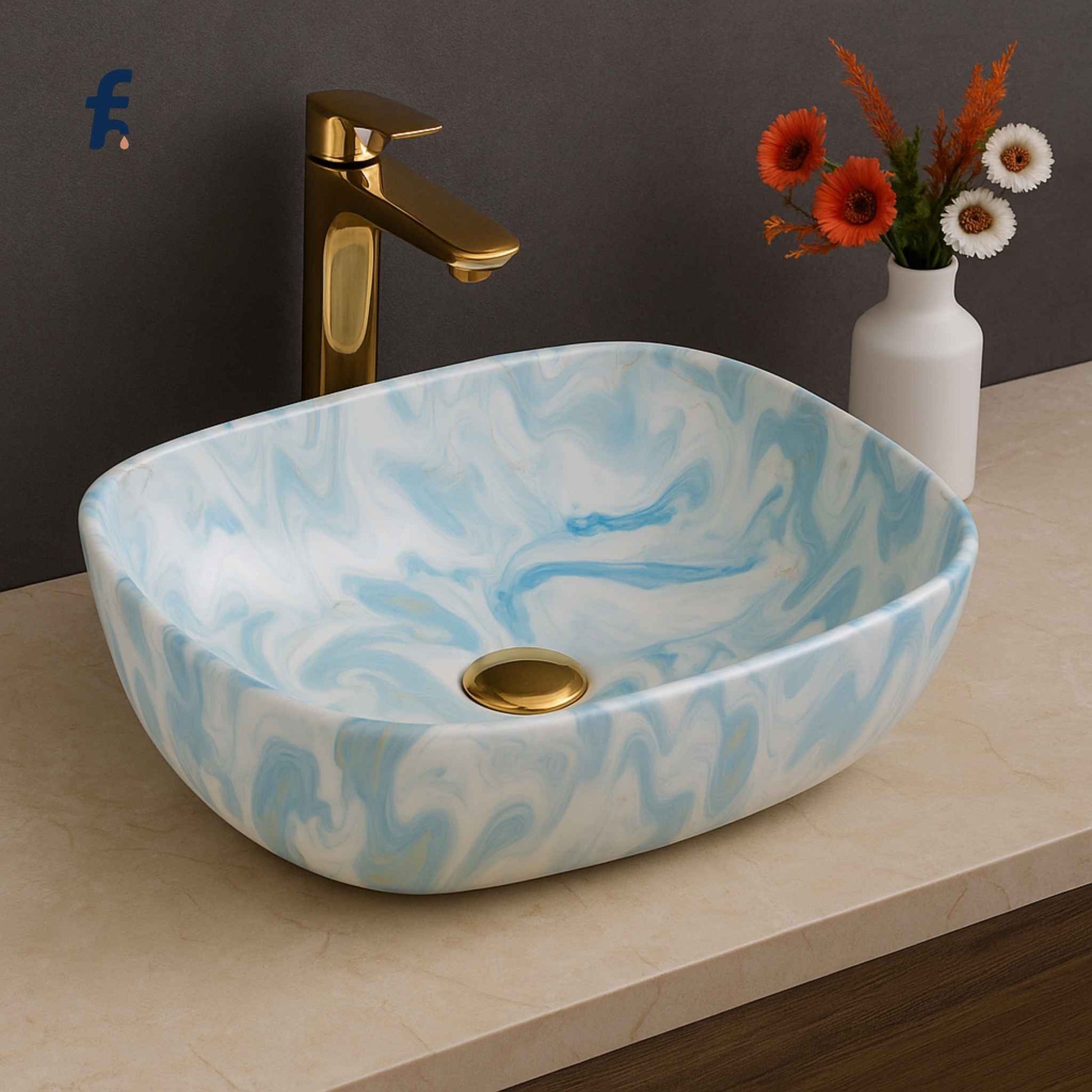 Marble-patterned sink with gold faucet and vase of flowers on a countertop,