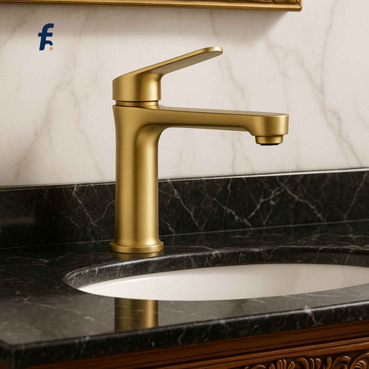 Gold faucet on a marble sink with a marble wall background