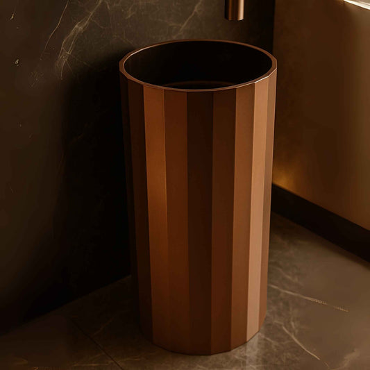 Close-up of copper pedestal sink showing detailed fluted metal texture