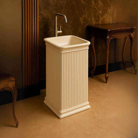Fluted pedestal basin in a marble-walled luxury bathroom with wood accents