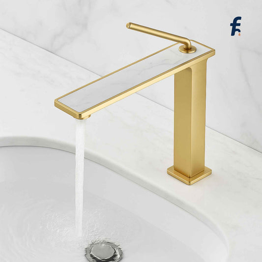 Gold faucet with water flowing into a sink on a white background, Close-up of gold and white marble designer basin mixer.