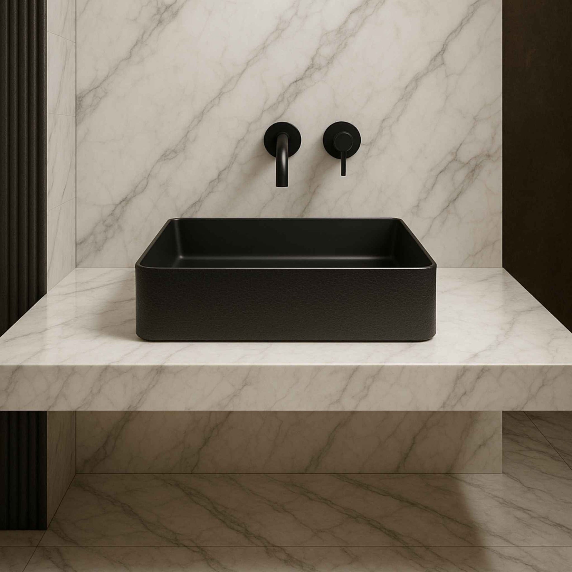 Black rectangular sink on a marble countertop with black fixtures.