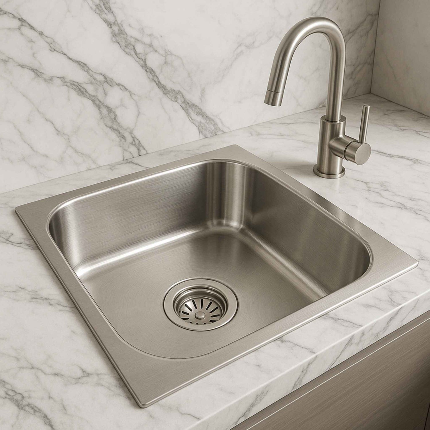 Single bowl stainless steel kitchen sink installed in marble countertop with designer faucet