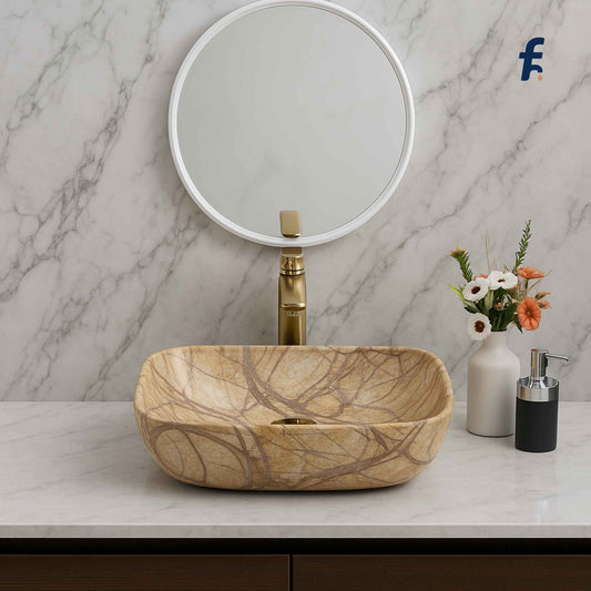 Marble sink with gold faucet against a marble wall