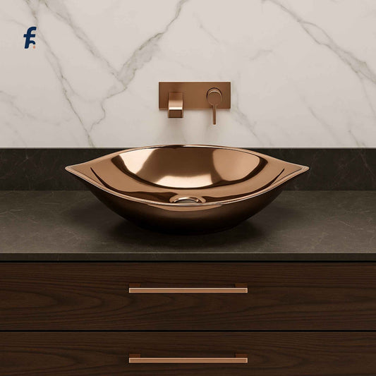 Rose gold sink and faucet on a marble and wooden vanity