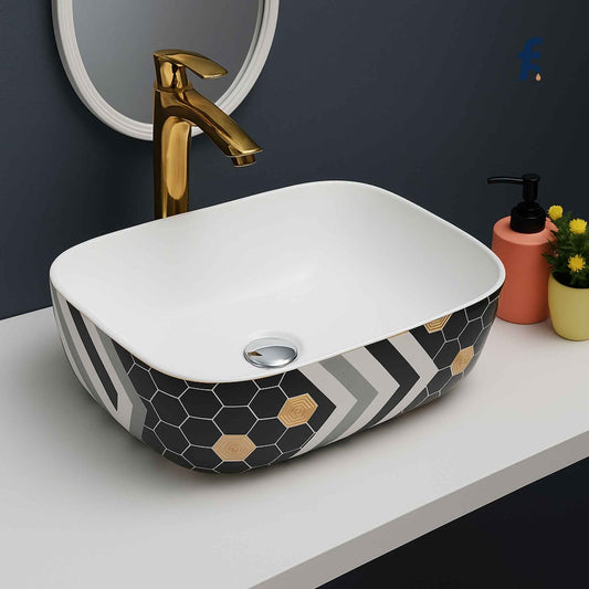 Bathroom sink with geometric pattern, gold faucet, and decorative items., 