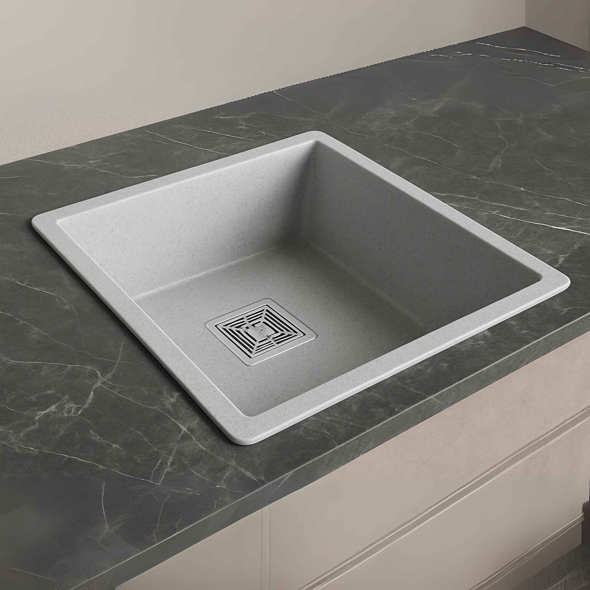 Side angle of grey granite sink placed on a stylish marble counter