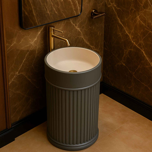 Grey fluted basin in a luxury bathroom with gold tap and marble wall