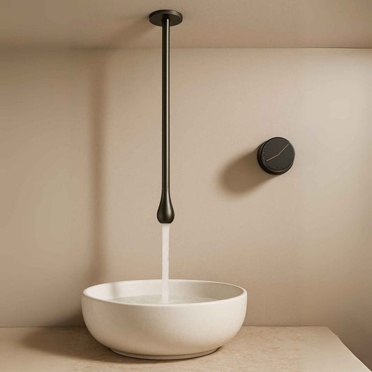 Side angle showing gun metal overhead waterfall faucet in luxury setting