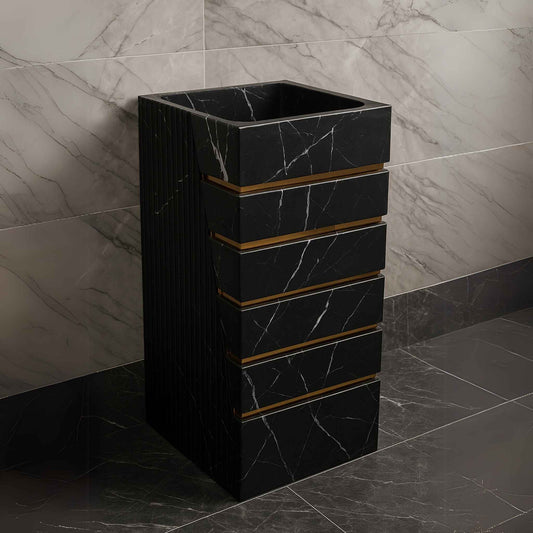 Black designer washbasin placed in luxury setting with dark marble tiles and gold fittings