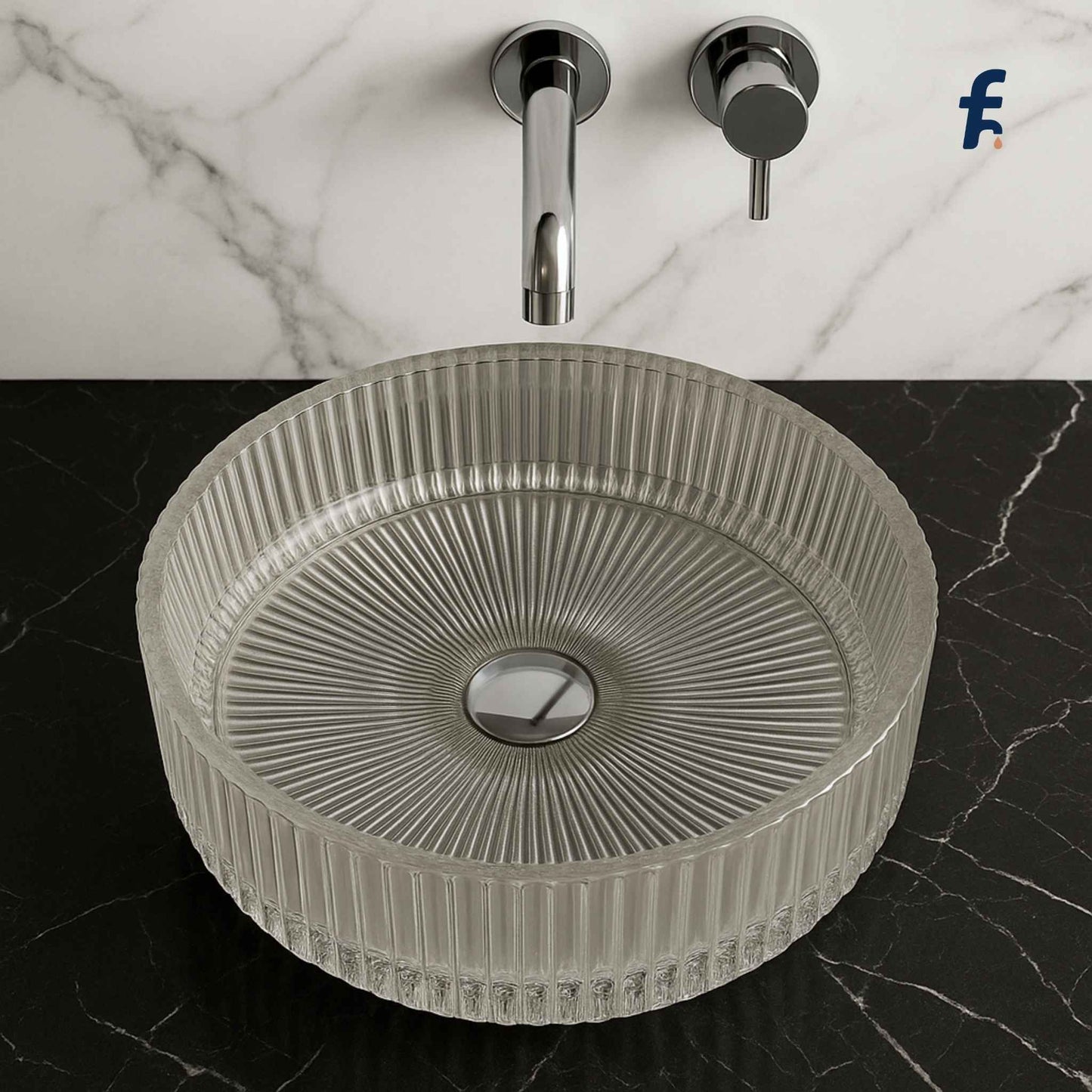 Round textured sink on a marble countertop with a faucet. Close-up top view of designer crystal glass basin with fluted edges.