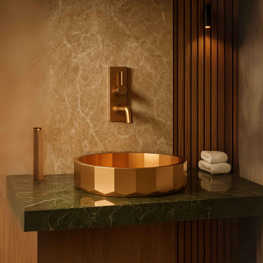 Front view of rose gold designer wash basin with faceted body in a luxury marble bathroom