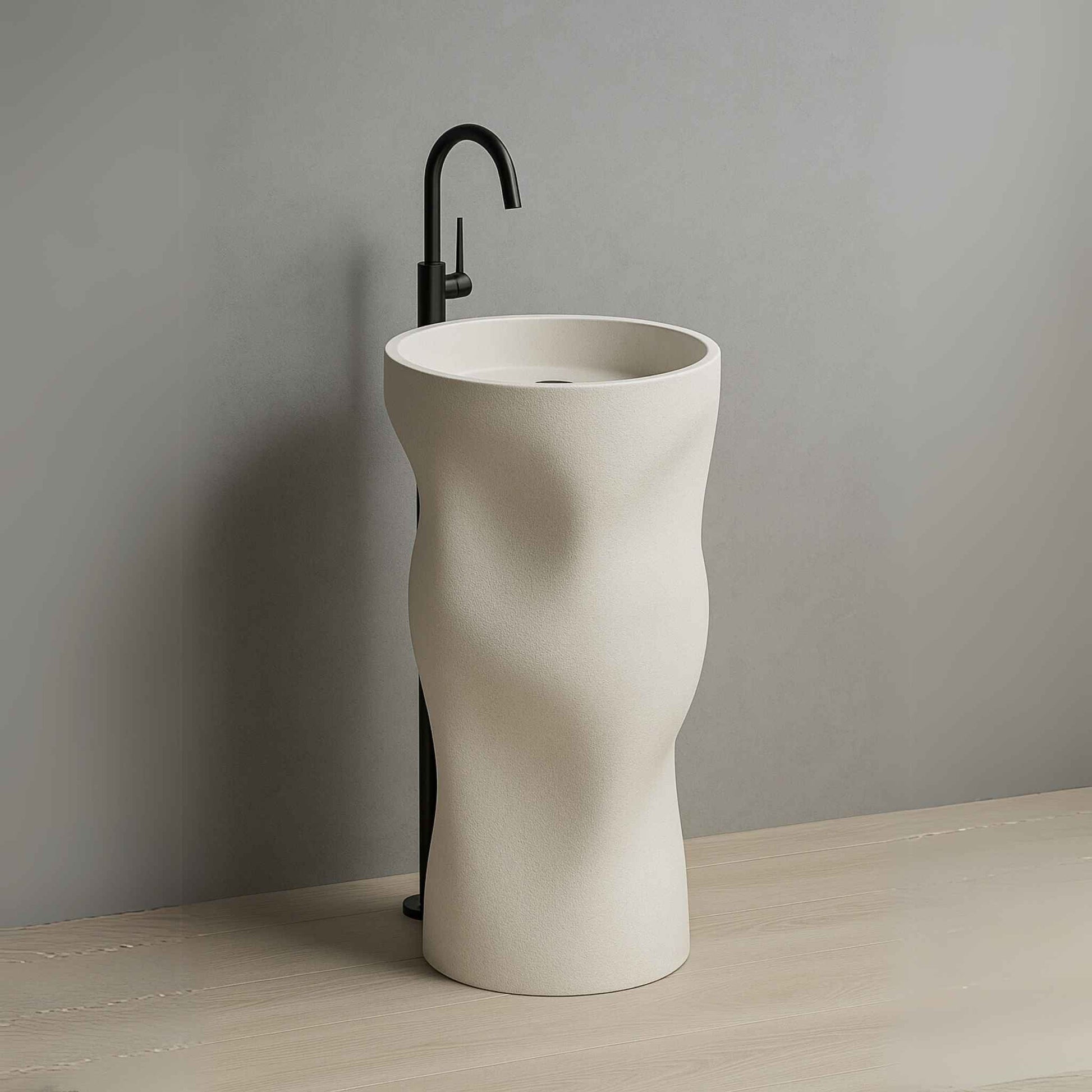 Luxury sculpted pedestal washbasin in matte ivory finish with wall-mounted black faucet placed in a high-end bathroom setting side angle