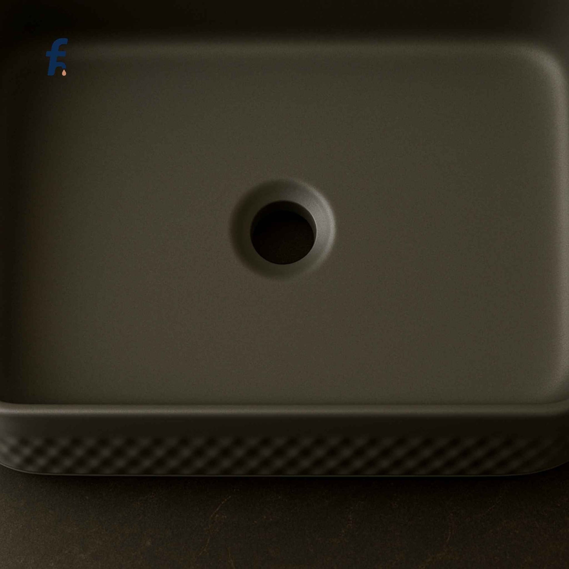 Dark gray rectangular object with a circular hole on a dark background