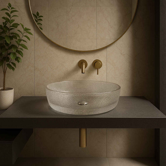 Bathroom sink with textured basin and gold fixtures against a beige wall.